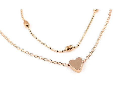 Gold heart-shaped necklace on a white background