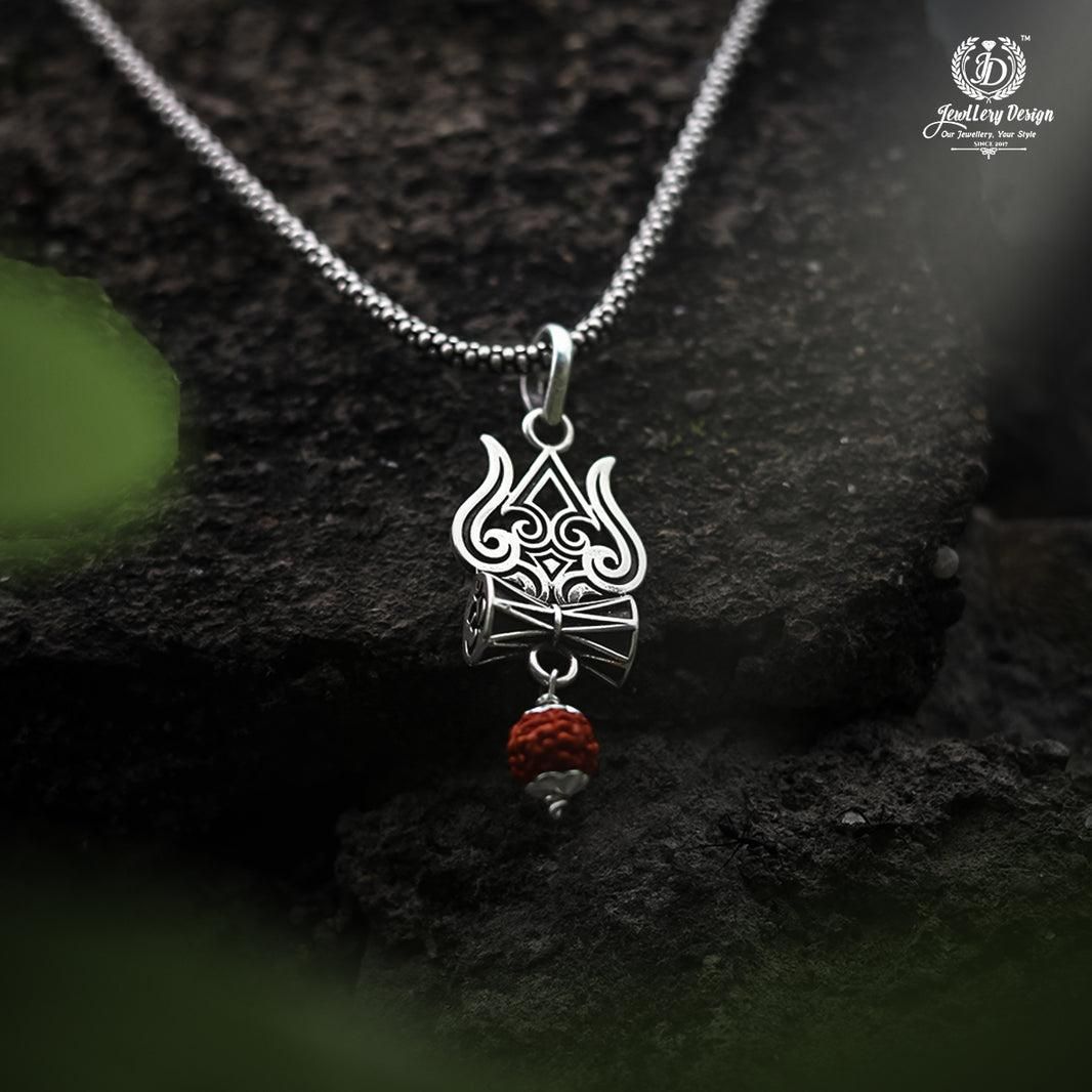 A silver oxidised Trishul Damru Rudraksha pendant chain with a small red bead on the pendant