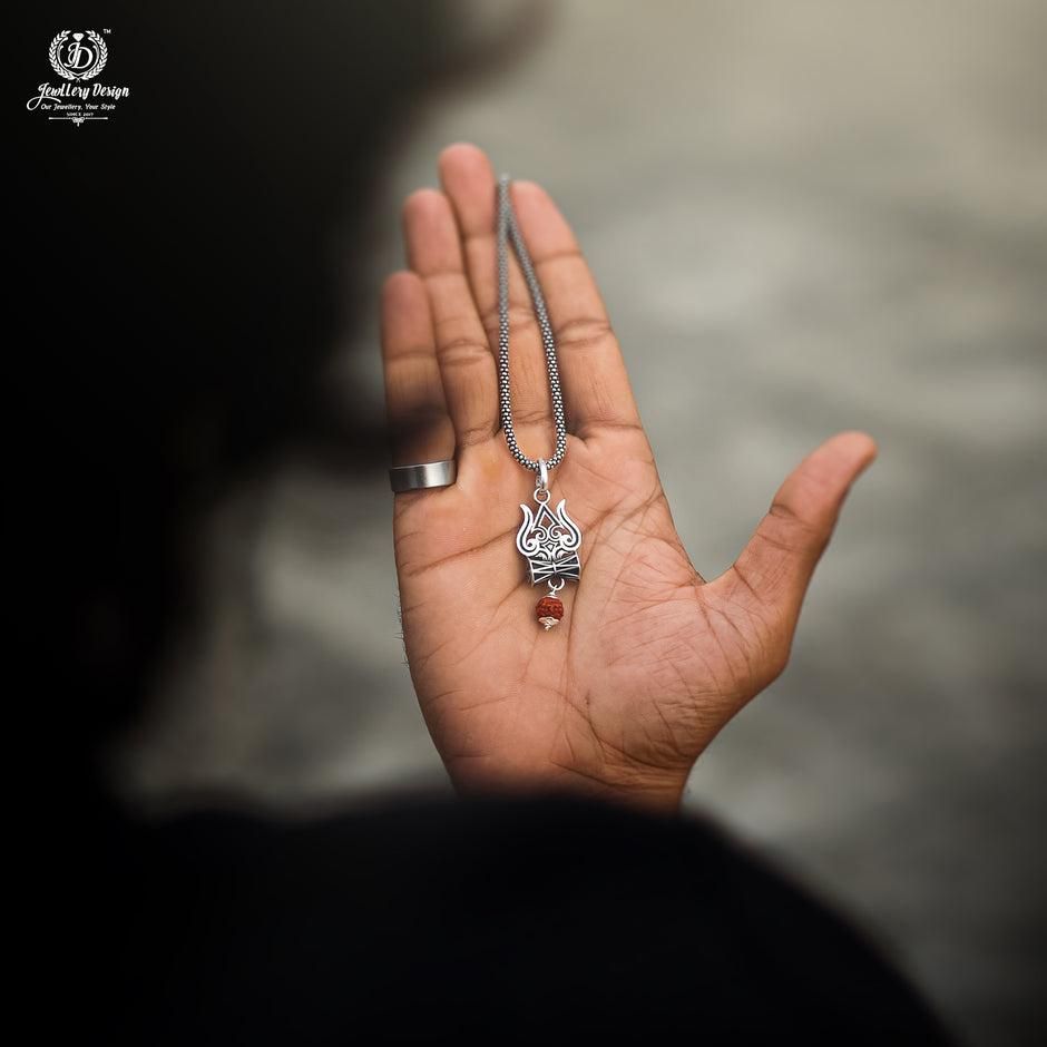 A silver oxidised Trishul Damru Rudraksha pendant chain with a small red bead on the pendant
