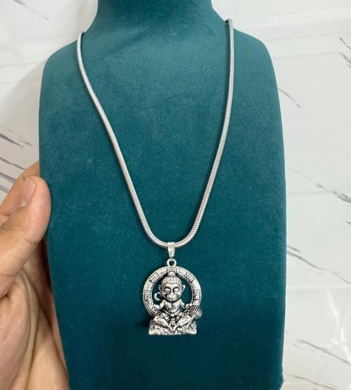 a silver-colored Lord Bal Hanuman pendant on a chain
