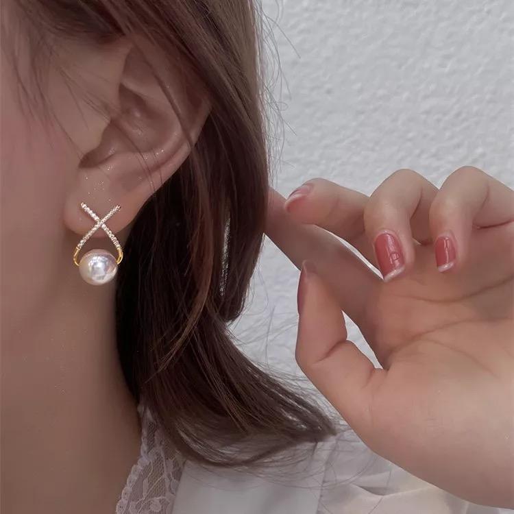 A pair of gold and silver platted cross pearl stud earrings with multicolor stones