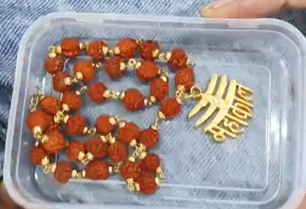 A Rudraksha Mala with red beads and a gold-colored Mahakal pendant