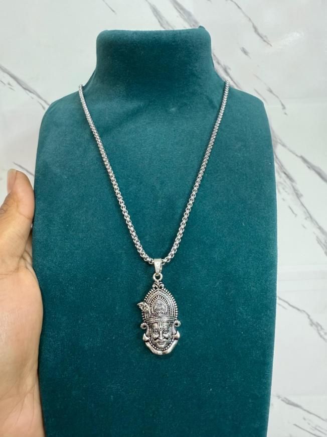 A silver stainless steel pendant in the shape of a Lord Shyam maharaj figure, displayed with a chain