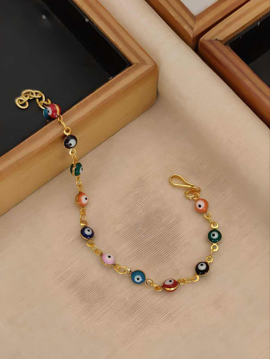 Colorful beaded bracelet with gold chain on a textured surface