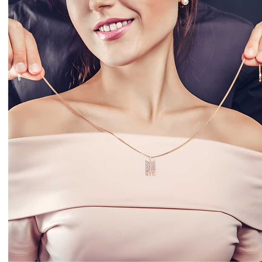 A woman wearing a off-shoulder top and showcasing a multicolor plated necklace with a pendant.