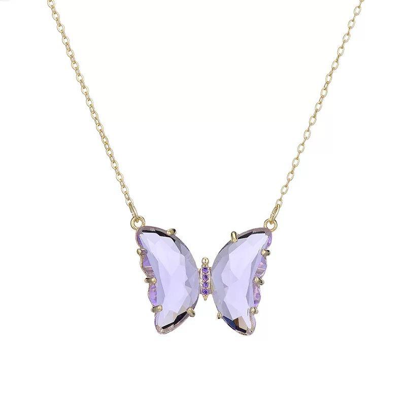 A gold-plated necklace with a stylish butterfly pendant, featuring multicolor (purple and pink) accents on a chain, displayed against a pink fabric background.