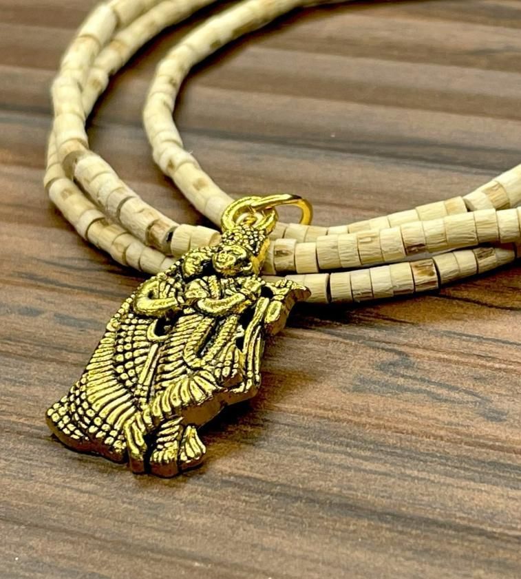 Two wooden Tulsi Mala necklaces with pendants, one depicting a bird and the other a geometric pattern, displayed against a wooden background.