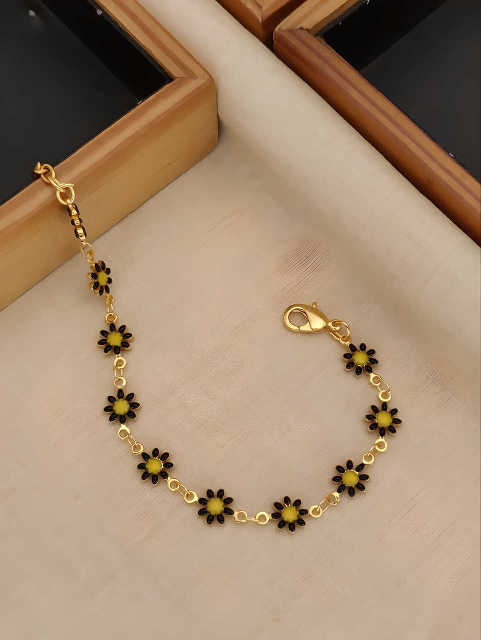 Elegant women's gold plated bracelet with black flower accents, ideal for daily wear and special occasions.