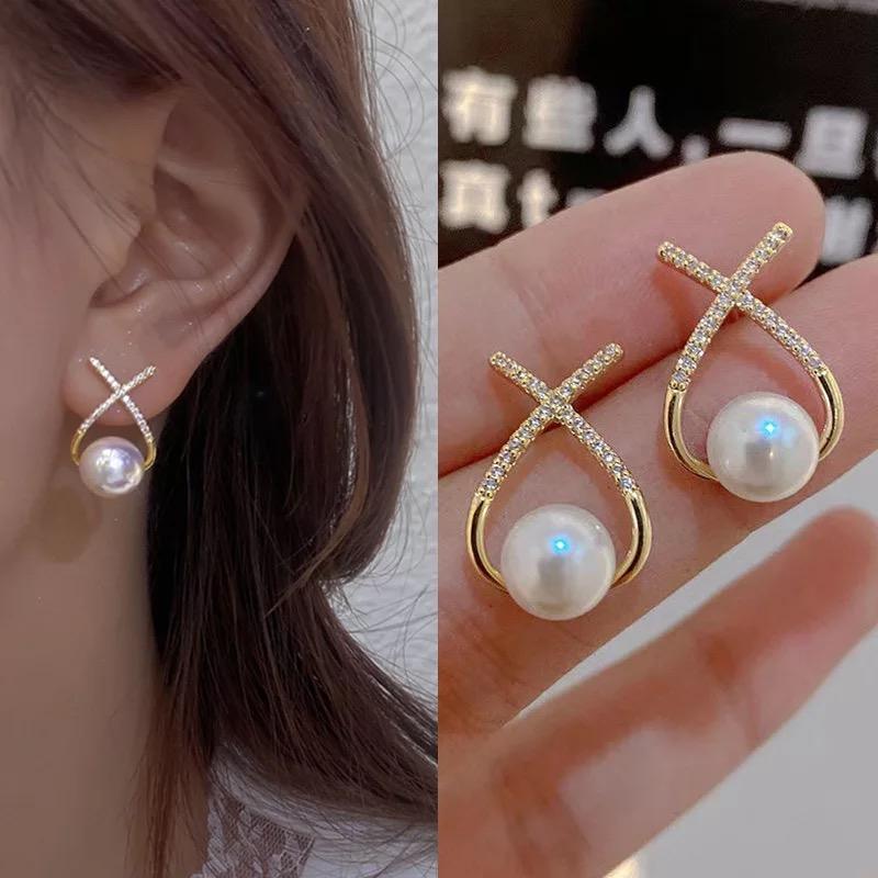 A pair of gold and silver platted cross pearl stud earrings with multicolor stones