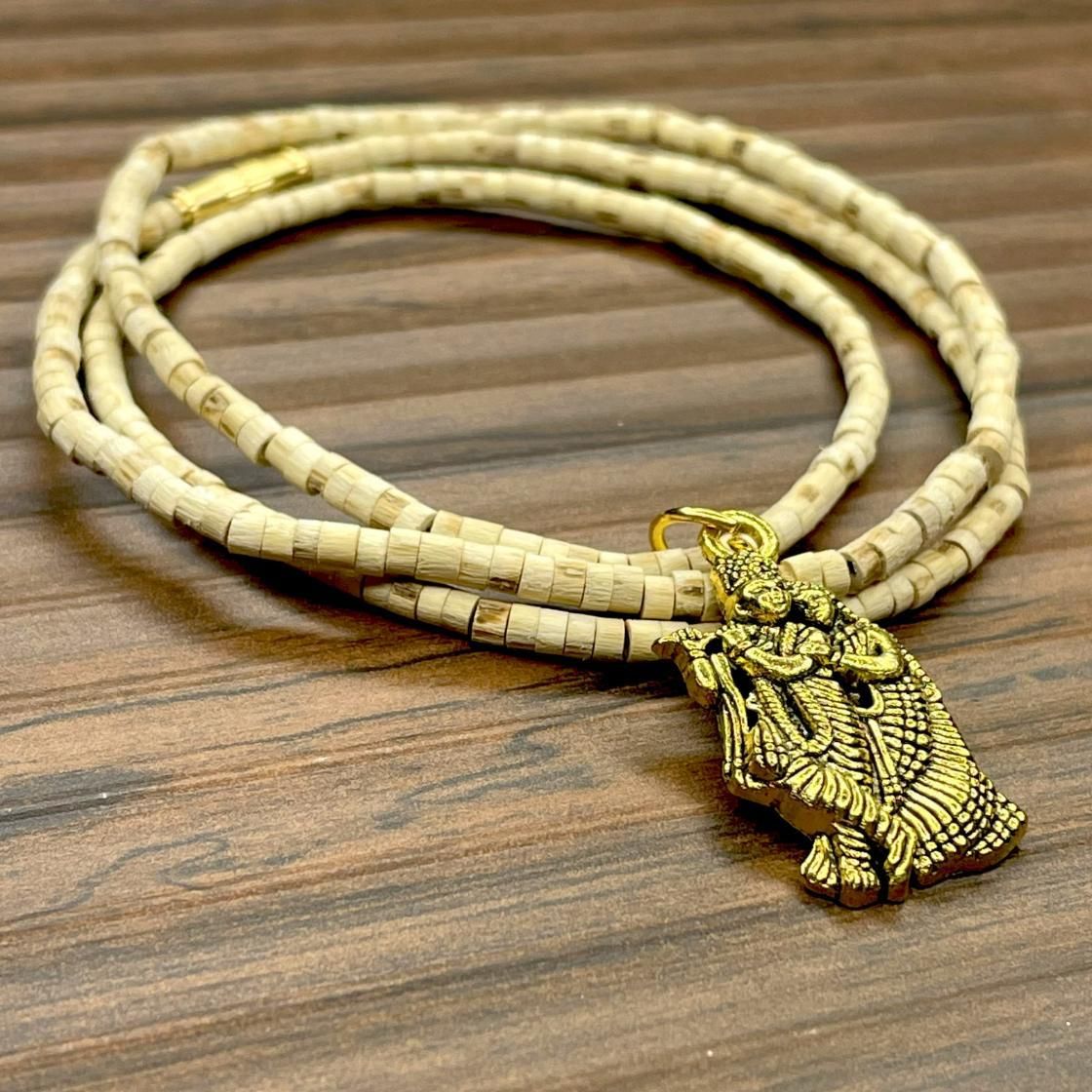 Two wooden Tulsi Mala necklaces with pendants, one depicting a bird and the other a geometric pattern, displayed against a wooden background.