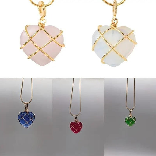 Heart-shaped pendant with rose gold wire wrapping on a soft pink fabric background