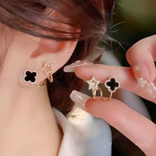 A person showing a pair of AVR JEWELS Korean Fashion Vibrato live four leaf Clover Earrings, with one earring in focus, gold and silver in color, featuring a four leaf clover design.
