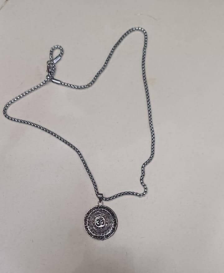silver pendant with an Om symbol