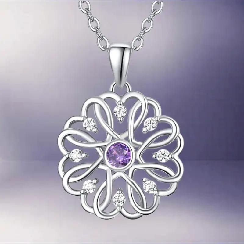 A silver birthstone pendant with a floral design, featuring a purple stone in the center, attached to a silver chain.