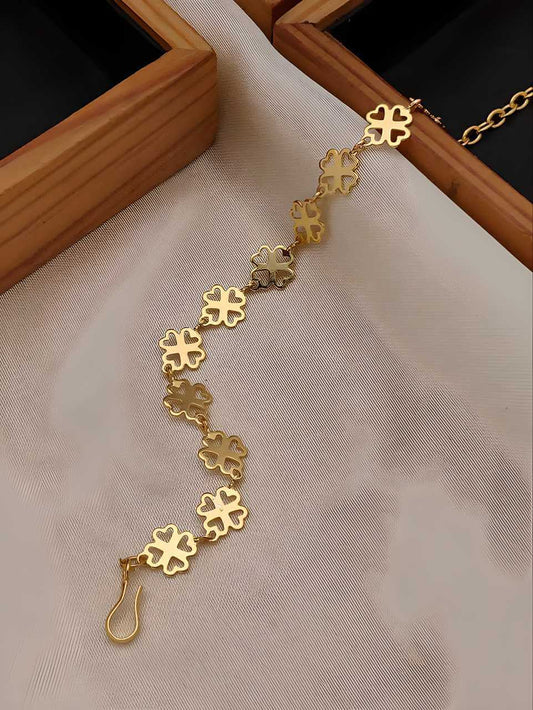 Gold floral bracelet on a beige fabric background