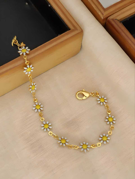 Gold bracelet with daisy flower charms on a beige surface