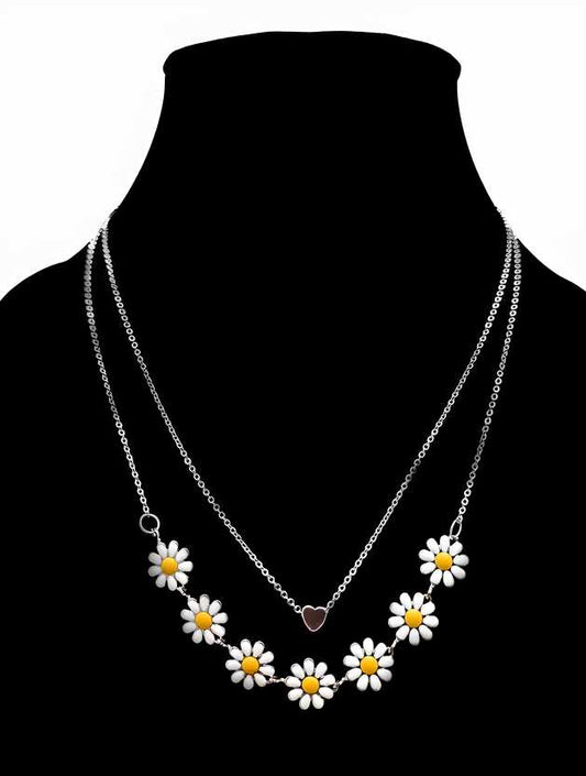 A two-layered necklace with gold-colored chains and daisy charms, displayed on a black mannequin.